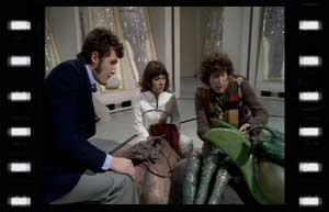 Image of Harry, Sarah Jane and the Doctor over a dead Wirm